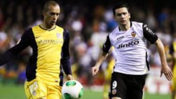 El defensa brasile&ntilde;o del Atl&eacute;tico de Madrid Joao Miranda  lucha el bal&oacute;n con el portugu&eacute;s Helder Postiga, del Valencia CF, durante el partido de ida de los octavos de final de la Copa del Rey que se disputa esta noche en el estadio de Mestalla, en Valencia. 