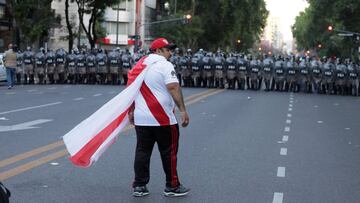 Un aficionado de River enfrente de un cordón policial en las inmediaciones del Monumental