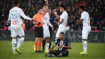 Paris (France), 27/10/2019.- French referee Benoit Bastien (C-L) gives a yellow card to Marseille's Hiroki Sakai (C-R) as Paris Saint Germain's Kylian Mbappe (down) looks on during the French Ligue 1 soccer match between PSG and Marseille at the