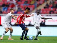 AME6164. GUADALAJARA (MÉXICO), 17/01/2026.- Efraín Álvarez (c) de Guadalajara disputa el balón con Carlos García (i) y Jean Unjanque (d) de Querétaro este sábado, durante un partido de la jornada 3 del torneo clausura 2026 de la Liga MX entre Guadalajara y Querétaro disputado en el Estadio Akron, en Guadalajara, Jalisco (México). EFE/ Francisco Guasco