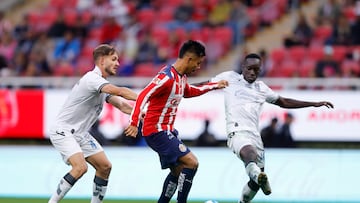 AME6164. GUADALAJARA (MÉXICO), 17/01/2026.- Efraín Álvarez (c) de Guadalajara disputa el balón con Carlos García (i) y Jean Unjanque (d) de Querétaro este sábado, durante un partido de la jornada 3 del torneo clausura 2026 de la Liga MX entre Guadalajara y Querétaro disputado en el Estadio Akron, en Guadalajara, Jalisco (México). EFE/ Francisco Guasco