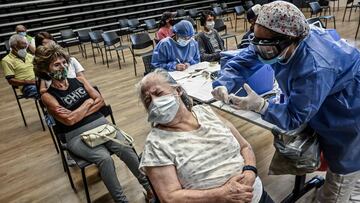 An elderly woman is inoculated with the Oxford/AstraZeneca vaccine against COVID-19 at a vaccination center, amid the novel coronavirus pandemic, in Medellin, Colombia, on April 7, 2021. - Colombian President Ivan Duque on Sunday reinforced the curfews he recently imposed in the cities with the highest hospital occupancy to contain a new wave of covid-19 infections and deaths. (Photo by JOAQUIN SARMIENTO / AFP)