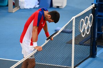El tenista serbio Novak Djokovic exhausto en la red tras perder el partido por el bronce contra Pablo Carreño.
