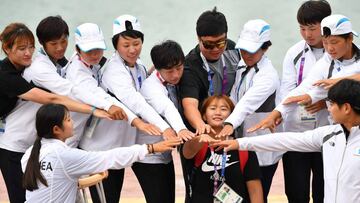 Female rowers from the Unified Korea team pose for photos after the awards ceremony for the canoe finals at the 2018 Asian Games in Palembang on August 27, 2018. (Photo by ADEK BERRY / AFP)