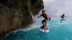 El surfista Kai Lenny, en foil rozando unas rocas, con Alex Hayes al fondo. En Haw&aacute;i, en mayo del 2023. 