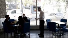Un mesero protegido con m&aacute;scara atiende una mesa en el restaurante &quot;Punta Sal&quot; el pasado 20 de julio, en Lima (Per&uacute;). EFE /Paolo Aguilar