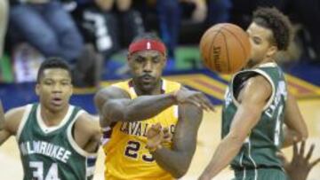 LeBron James da un pase ante la mirada de Antetokounmpo.