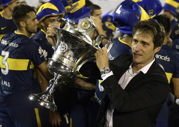 Boca Juniors' coach Guillermos Barros Schelotto holds the trophy celebrating winning the Argentina First Division Superliga championship after a tie 2-2 with Gimnasia y Esgrima La Plata at Juan Carmelo Zerillo stadium in La Plata, Buenos Aires, Argentina, on May 9, 2018. / AFP PHOTO / JUAN MABROMATA