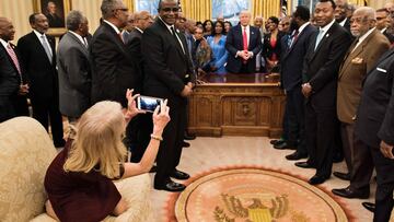 TOPSHOT - Counselor to the President Kellyanne Conway takes a photo as US President Donald Trump and leaders of historically black universities and colleges talk before a group photo in the Oval Office of the White House before a meeting with US Vice President Mike Pence February 27, 2017 in Washington, DC. / AFP PHOTO / Brendan Smialowski