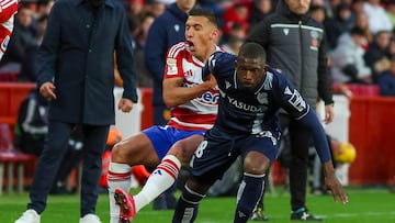 GRANADA, 09/03/2024.- El delantero albanés del Granada Myrto Uzuni (i) cae tras la entrada de Hamari Traoré, de la Real Sociedad, durante el partido de la jornada 28 de LaLiga que enfrenta a los equipos del Granada CF y Real Sociedad hoy sábado en el estadio Nuevo Los Carmenes, en Granada. EFE/Pepe Torres.