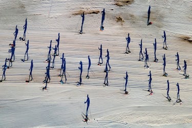 En la imagen aparece un grupo de participantes en la carrera popular de esquí nórdico Nordi Cki Marxa Beret que se disputa en Baqueira Beret (Lleida). El fotógrafo ha tomado una preciosa fotografía en la que la perspectiva hace que se vean sombras enormes de los deportistas, que apenas llegan a ser apreciados. 
