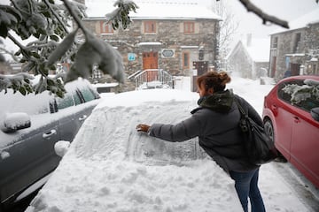 Una mujer limpia la nieve de su coche en Pedrafita do Cebreiro, Lugo, Galicia. 