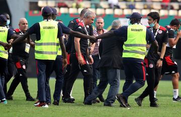 Los miembros de seguridad desalojan el terreno de juego.