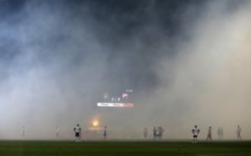 Players wait for smoke to clear from the field after soccer fans burned torches during a Serbian National soccer league derby match between Partizan and Red Star, in Belgrade, Serbia, Saturday, Feb. 27, 2016. Red Star won 1-2. (AP Photo/Darko Vojinovic)