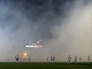 Players wait for smoke to clear from the field after soccer fans burned torches during a Serbian National soccer league derby match between Partizan and Red Star, in Belgrade, Serbia, Saturday, Feb. 27, 2016. Red Star won 1-2. (AP Photo/Darko Vojinovic)