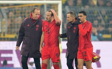 Harry Kane of Munich (2-L) leaves injured the pitch during the German Bundesliga soccer match between Borussia Dortmund and FC Bayern Munich