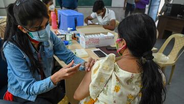 A health worker inoculates a woman with a dose of the Covishield vaccine against the Covid-19 coronavirus at the vaccination centre in New Delhi on May 22, 2021. (Photo by Prakash SINGH / AFP)