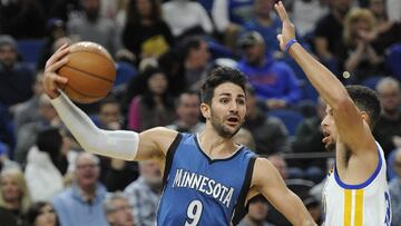 Ricky Rubio da un pase defendido por Stephen Curry.