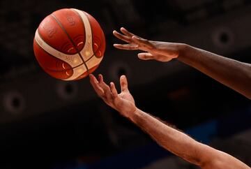 Las manos de Sajjad Mashayekhi y Usman Garuba luchan por el balón.