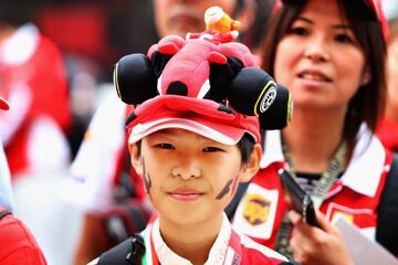 Joven fan de Ferrari con un gorro con un monoplaza de la escuder赤a italiana.