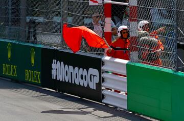 Operario de la carrera ondea la bandera roja tras el accidente de Checo Pérez. 