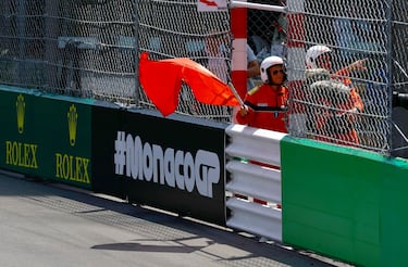 Operario de la carrera ondea la bandera roja tras el accidente de Checo Pérez. 