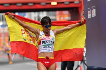 María Pérez posa con la bandera española tras llegar a la línea de meta la primera y ganar así la medalla de oro.
