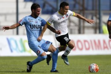 El jugador de Colo Colo, Javier Reina, centro, disputa el balon con Tomas Charles de Deportes Iquique durante el partido de primera division en el estadio Tierra de Campeones de Iquique, Chile.