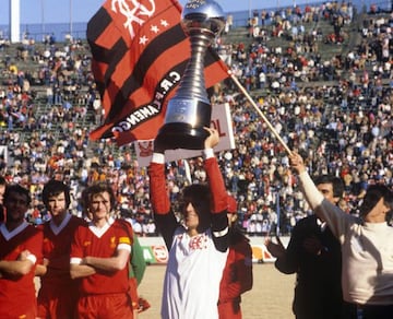 Flamengo captain Zico holds up the Toyota Cup. Liverpool's Ray Kennedy, Alan Hansen and Phil Thompson look on.