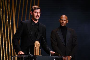 El portero belga del Real Madrid, Thibaut Courtois, recibe el Trofeo Yashin al mejor portero de manos del delantero marfileño de Dortmund, Sebastien Haller.