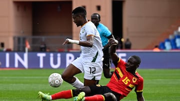 Zimbabwe's midfielder #12 Bill Antonio (L) is tackled by Angola's midfielder #15 Beni Mukendi during the Africa Cup of Nations (CAN) Group B football match between Angola and Zimbabwe at Marrakesh Stadium in Marrakesh on December 26, 2025. (Photo by Khaled DESOUKI / AFP)