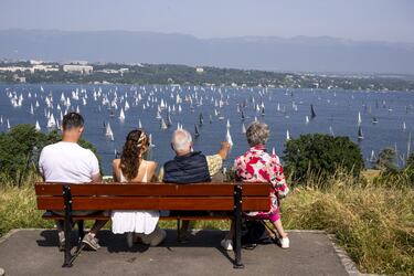 Cuatro privilegiados espectadores observan, desde un banco de madera en una zona elevada, la salida de la 86ª edición de la regata Bol dOr, que tiene lugar en el lago Lemán o lago de Ginebra, en Suiza. Alrededor de 404 embarcaciones participan durante el fin de semana en la mayor regata de vela celebrada en el mayor lago de la Europa Occidental.
