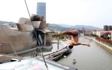 El clavadista colombiano Miguel García, durante los entrenamientos para las finales del 'Red Bull Cliff Diving 2015' de Bilbao, ante el Museo Guggenheim de la capital vizcaína.