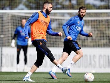 Benzema, en el entrenamiento de este viernes, da un pase ante la mirada de Nacho.