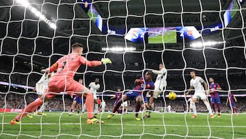 Real Madrid's English midfielder #5 Jude Bellingham (3rdR) challenges Barcelona's German goalkeeper #01 Marc-Andre ter Stegen during the Spanish league football match between Real Madrid CF and FC Barcelona at the Santiago Bernabeu stadium in Madrid on April 21, 2024. (Photo by Thomas COEX / AFP)