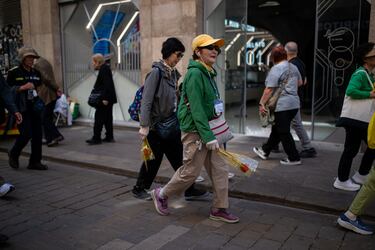Transeúntes paseando con rosas, durante la Diada de Sant Jordi 2025.