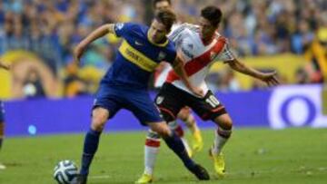 Fernando Gago (i) de Boca Juniors disputa el balón con Manuel Lanzini de River Plate hoy, domingo 30 de marzo de 2014, durante el partido del Torneo Apertura de Argentina en el estadio de la Bombonera de Buenos Aires (Argentina).