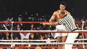 <b>FOREMAN, EN LA NOCHE DE LA LONA. </b>En la noche tropical de Kinshasa, el árbitro Zack Clayton, envía a Muhammad Alí al rincón. A sus pies, fuera de combate, George Foreman.
