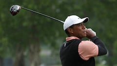 Tiger Woods plays his shot from the ninth tee as rain falls during the third round of the PGA Championship golf tournament at Southern Hills Country Club