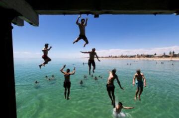 Las altas temperaturas que vive Australia (42.9 grados) hacen que muchos se refresquen de esta manera en Henley Beach, en Adelaida. 