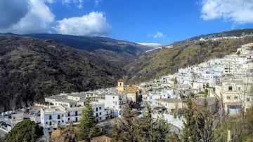 La arquitectura de este pueblo ubicado en la vertiente sur de Sierra Nevada conserva la esencia de su pasado bereber. De calles sinuosas y empinadas destacan sus casas de piedra encalads son los típicos ‘terraos’ (tejados planos cubiertos de launa) y ‘tinaos’ (soportales de acceso a las viviendas), y permite contemplar las cimas de los majestuosos Veleta y Mulhacén.