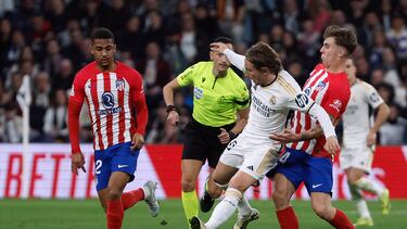 El centrocampista del Real Madrid Luka Modric (c) pelea un balón con Pablo Barrios (d) y Samuel Lino, ambos del Atlético, durante el partido de LaLiga de fútbol que Real Madrid y Atlético de Madrid han disputado este domingo en el estadio Santigo Bernabéu.