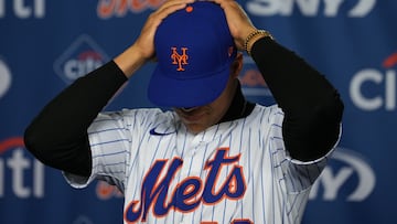New York Mets Dominican superstar Juan Soto puts on a Mets cap during a press conference in New York on December 12, 2024. Soto joined the New York Mets on a record-breaking 15-year, $765 million deal on December 9. (Photo by DAVID DEE DELGADO / AFP)