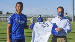 Luis Su&aacute;rez recibe de manos de Christian Lapetra una camiseta firmada por todos sus compa&ntilde;eros, que esta ma&ntilde;ana le han despedido en la Ciudad Deportiva.