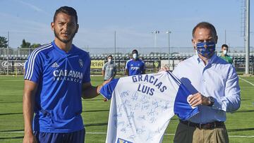 Luis Su&aacute;rez recibe de manos de Christian Lapetra una camiseta firmada por todos sus compa&ntilde;eros, que esta ma&ntilde;ana le han despedido en la Ciudad Deportiva.