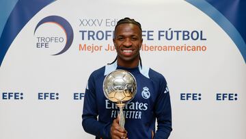 MADRID, 31/12/2024.- El delantero brasileño del Real Madrid Vinicius jr. posa con el Trofeo EFE al Mejor Jugador Iberoamericano de Fútbol antes de participar en el entrenamiento realizado este martes, último día del año, en Valdebebas.Tras regresar el lunes al trabajo después del descanso navideño, el Real Madrid, que el viernes visita al Valencia en un partido pendiente de la duodécima jornada y que fue aplazado por la dana, se entrena este martes a puerta abierta, con acceso único para los socios del club. EFE