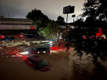 Vehículos parcialmente sumergidos bajo el agua tras el paso de la DANA por Valencia.