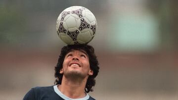 (FILES) In this file picture taken on May 22, 1986 Argentine football star Diego Maradona, wearing a diamond earring, balances a soccer ball on his head as he walks off the practice field following the national team's practice session in Mexico City. - Argentine football legend Diego Maradona turns 60 on October 30, 2020. (Photo by JORGE DURAN / AFP)