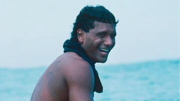 Dane Kealoha sonriendo sobre su tabla de surf en Hawái.