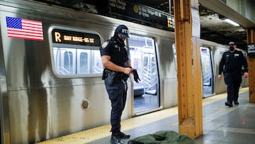 A New York Police Officer of the anti terrorism unit prepares to inspect a jacket left in a train as he patrols the 36th St. subway station, a day after a shooting incident took place in the Brooklyn borough of New York City, U.S., April 13, 2022.  REUTERS/Eduardo Munoz